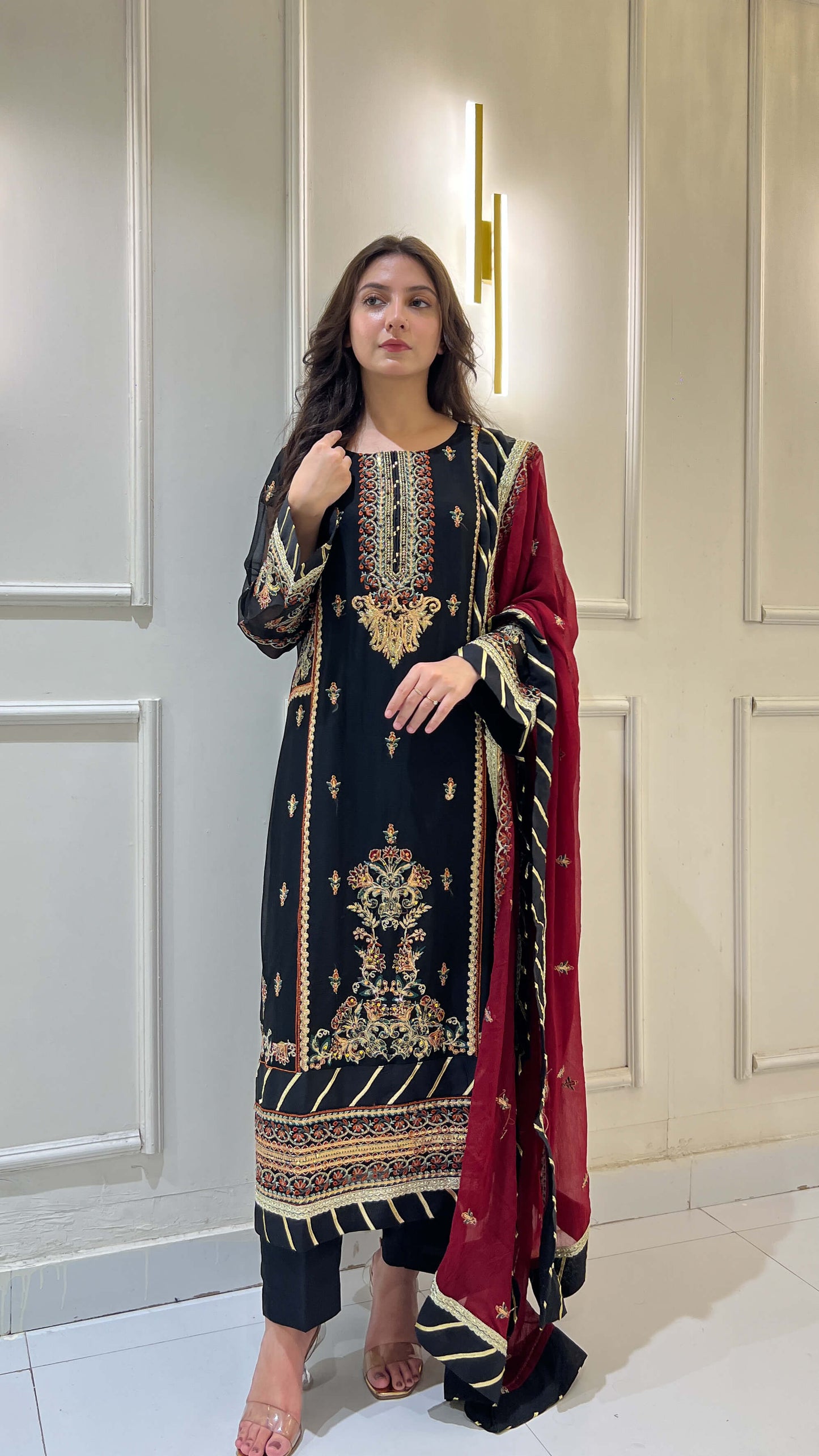 Chiffon maroon dupatta flowing with embroidered black kameez, elegant traditional fashion look