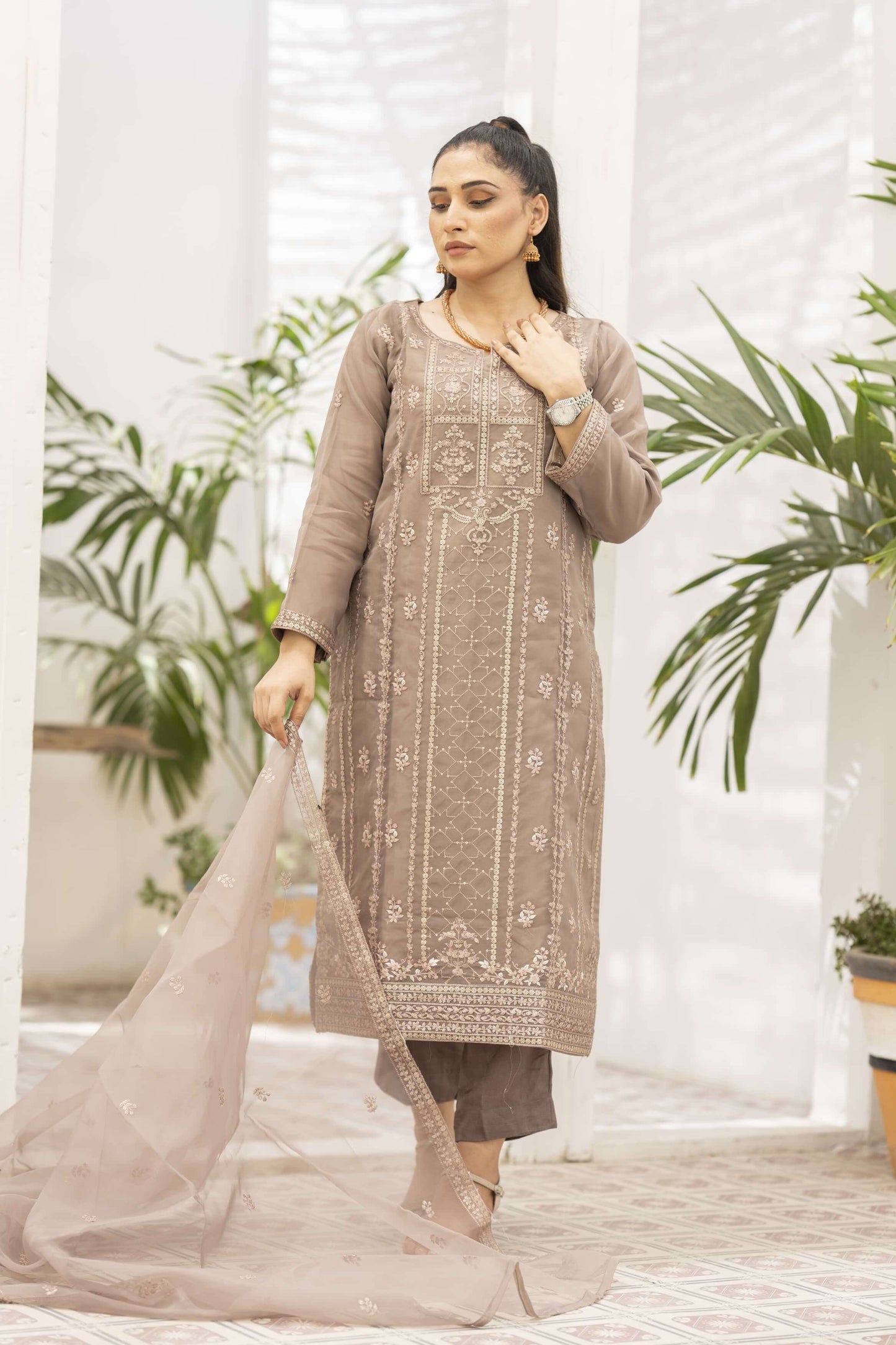 Woman wearing a light brown embroidered kurta with a dupatta