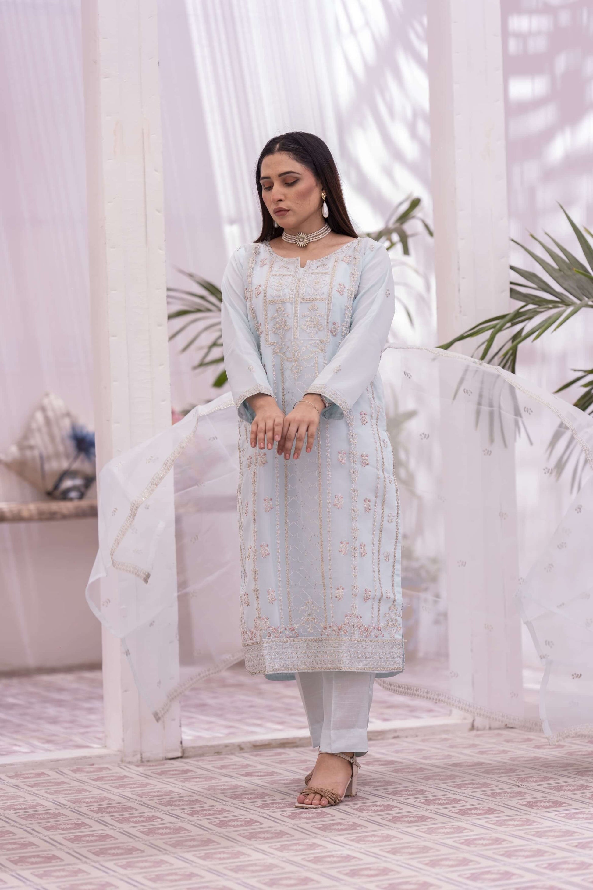 Woman in a light blue embroidered organza traditional outfit 