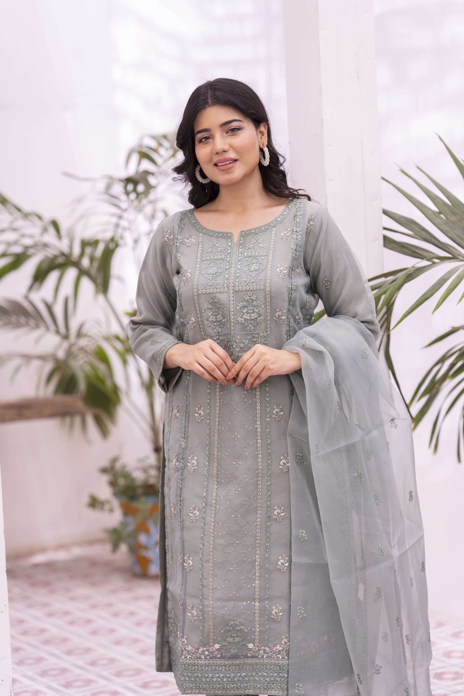Woman wearing a green embroidered organza outfit with a dupatta
