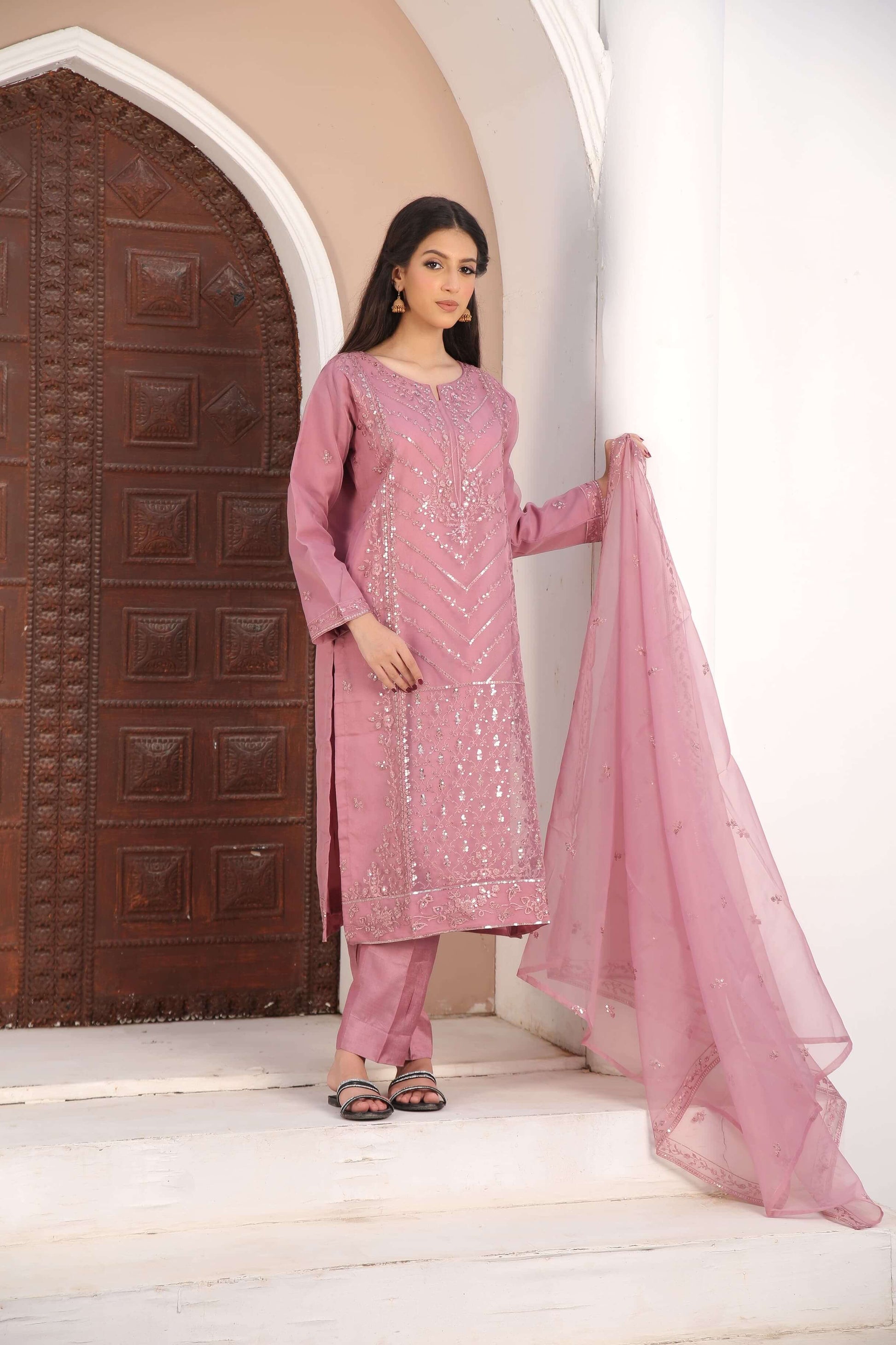 Woman in a pink traditional organza fabric shalwar kameez outfit Front standing 