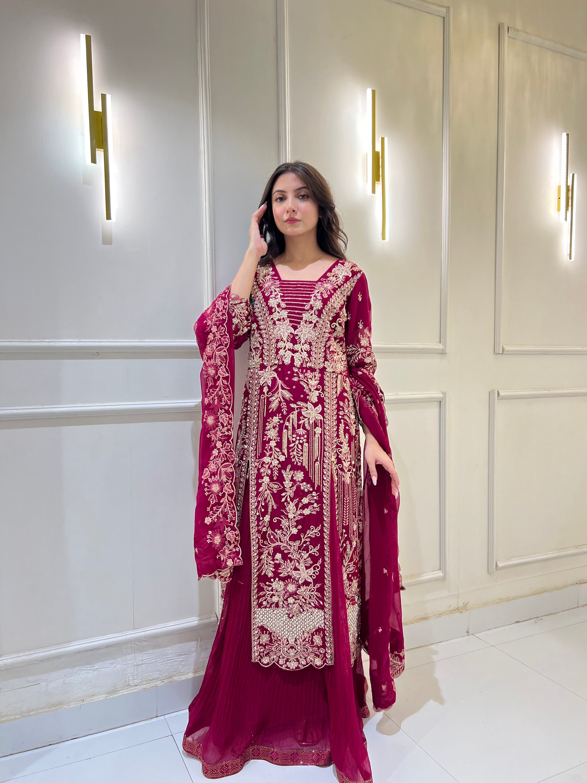Model wearing magenta embroidered ijaar lehnga suit, twirling and walking to show fabric movement, embroidery details, and ijaar pant design.